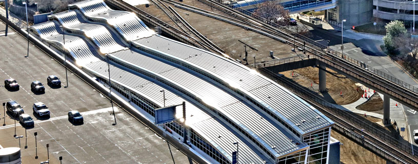 Aerial view of rail terminal connected to airport.